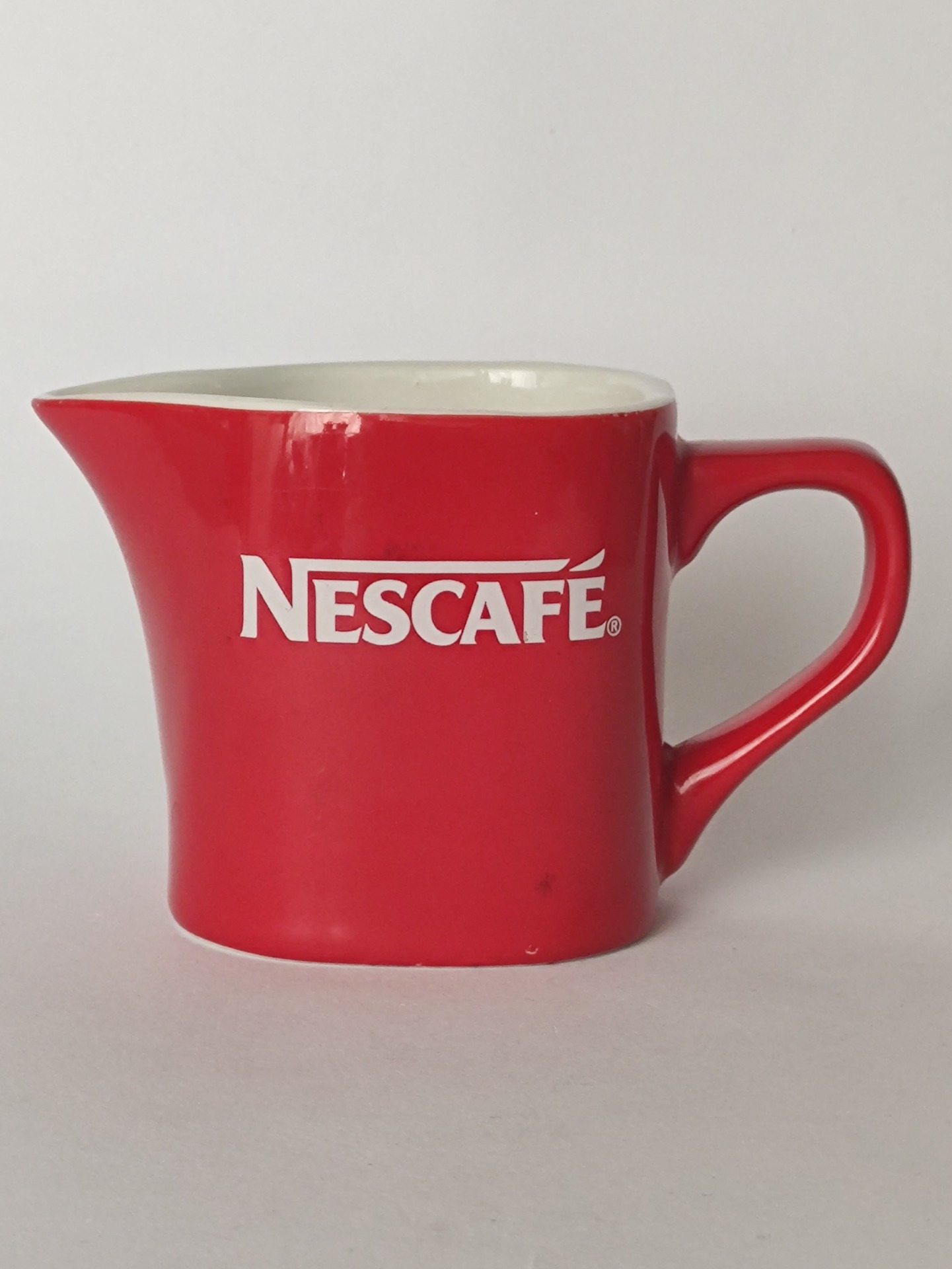 Červená konvička s logem Nescafé
